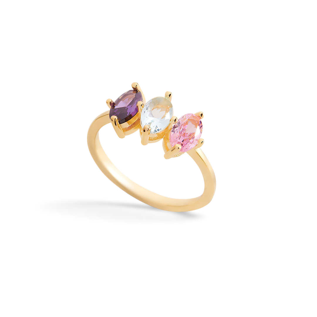 Gold ring with three colorful gemstones on a light gray background