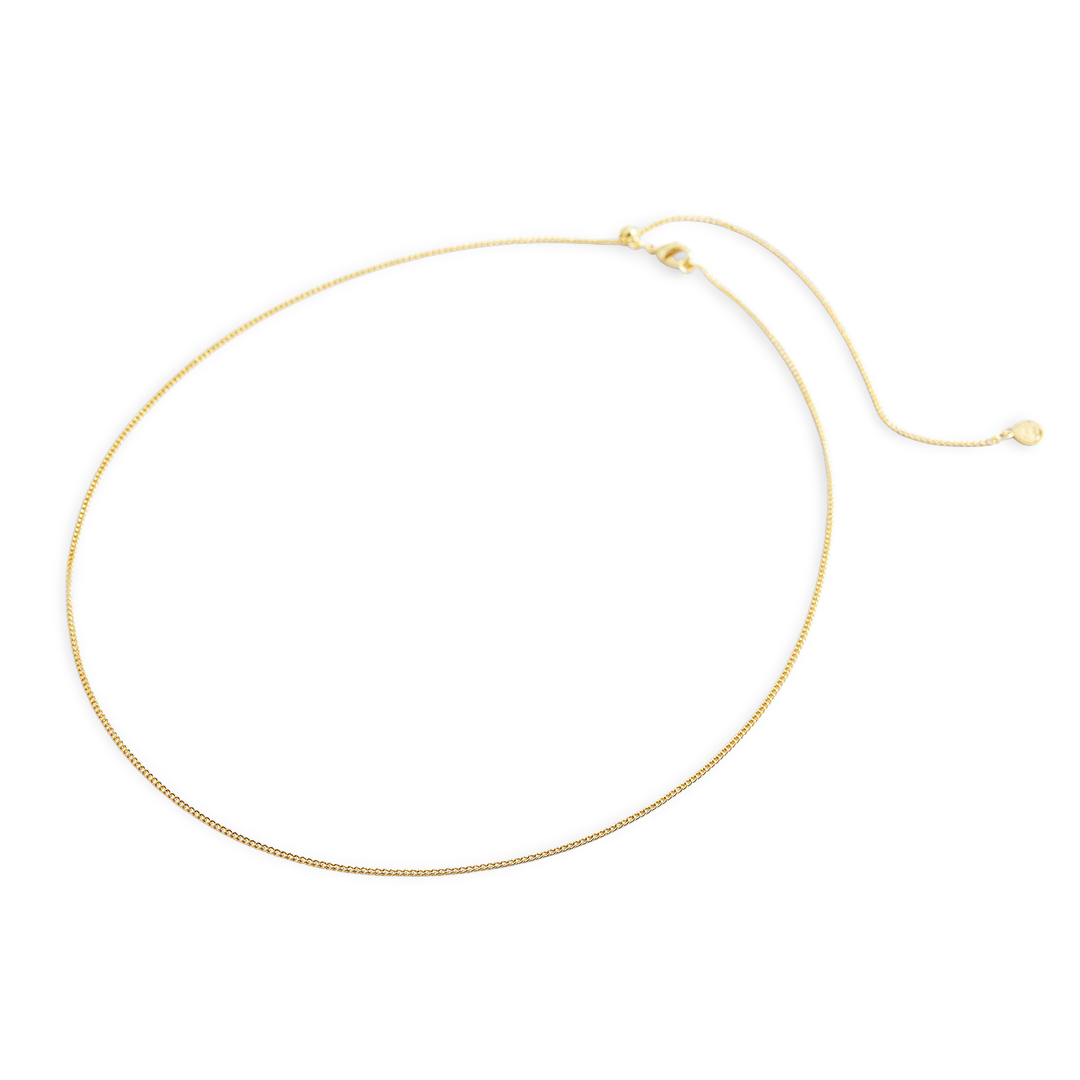 Gold necklace on a light gray background