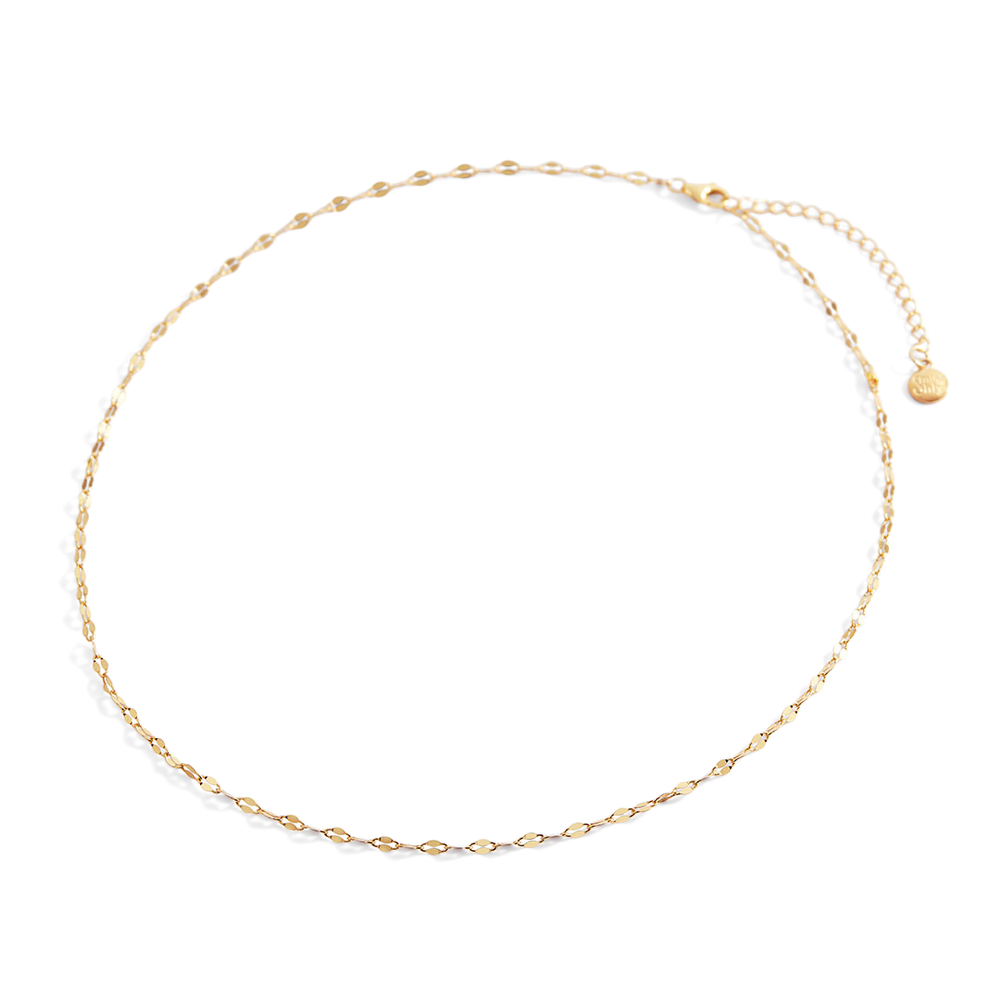 Gold necklace on a light gray background