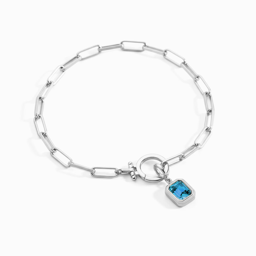 Silver bracelet with a blue gemstone charm on a white background