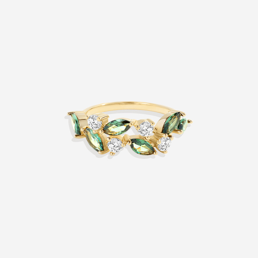 A leaf-inspired ring with green marquise stones and gold-colored metal, set against a white background.