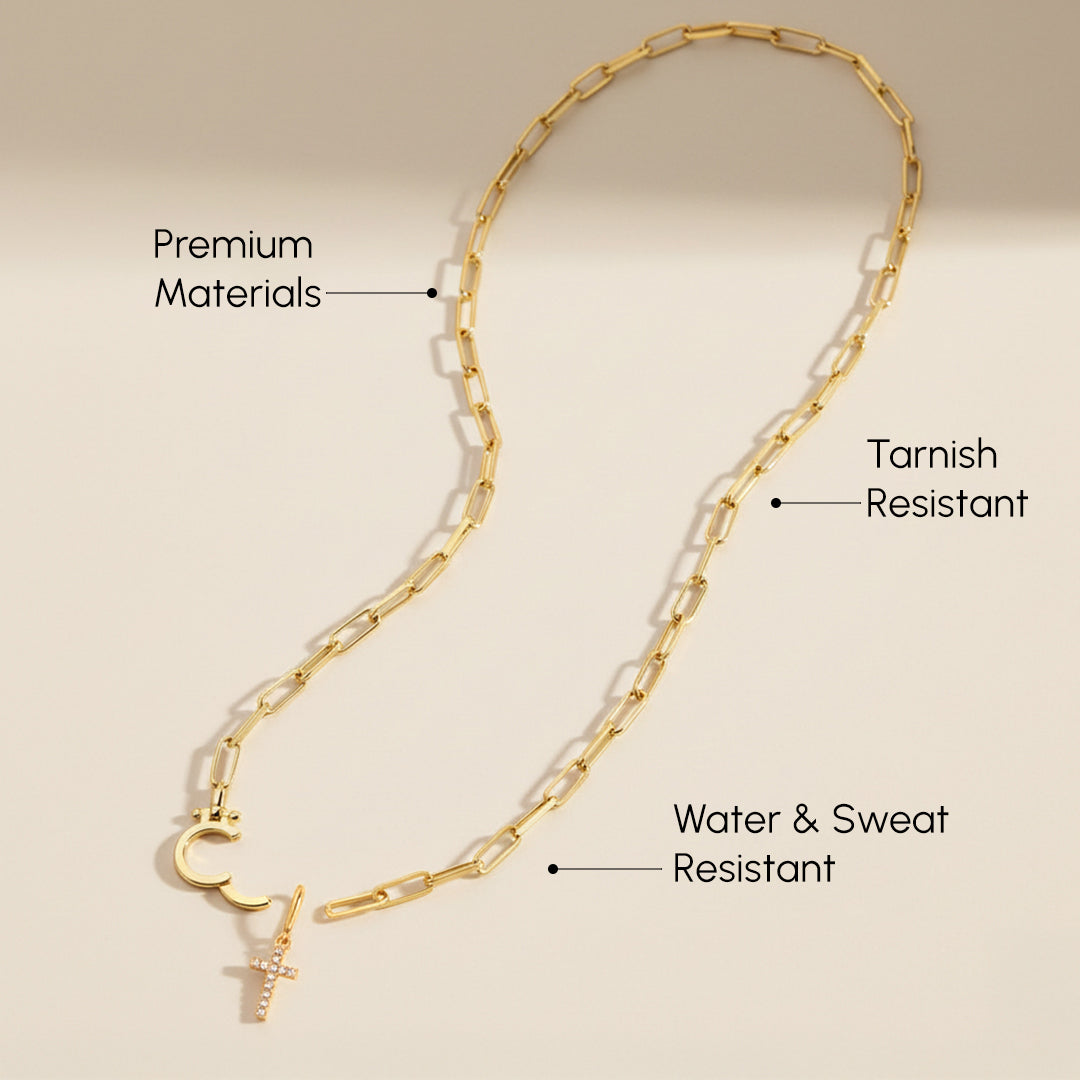 Gold chain necklace with pendant on a beige background, labeled for material and durability features.