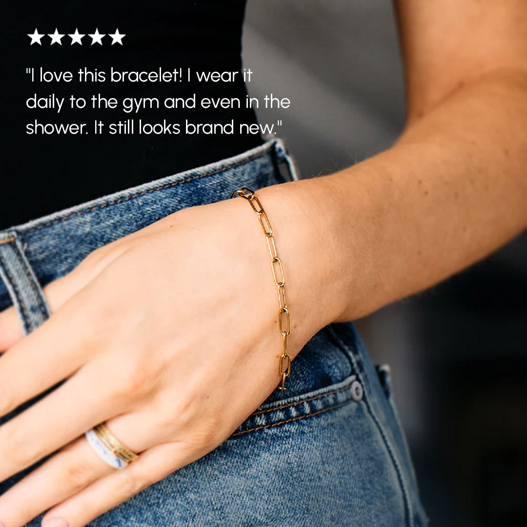 Gold bracelet worn on a wrist with text about its durability.