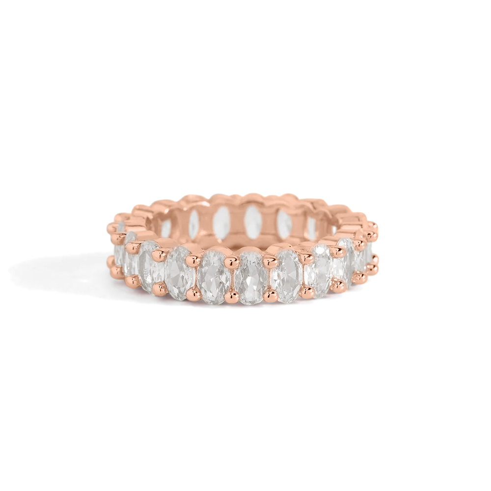 A gold-colored eternity ring with oval-shaped stones set around its entire circumference.