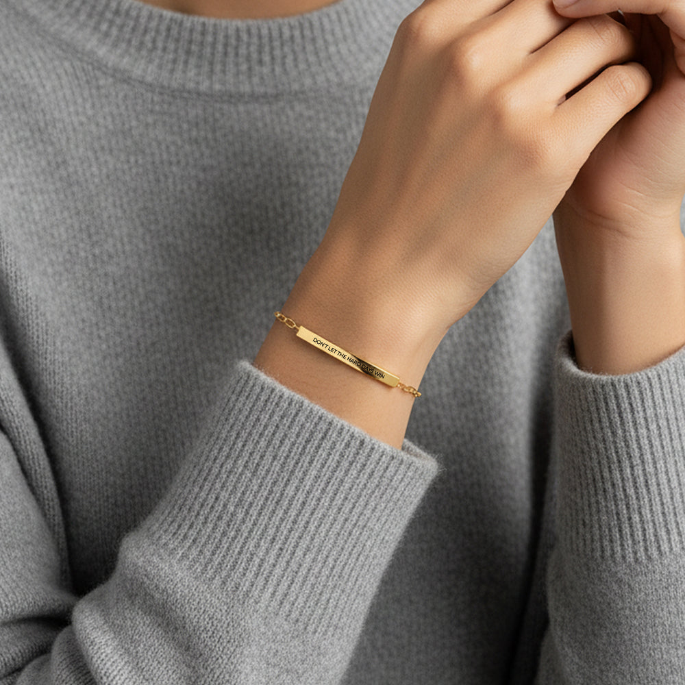 Gold bracelet on a person wearing a gray sweater