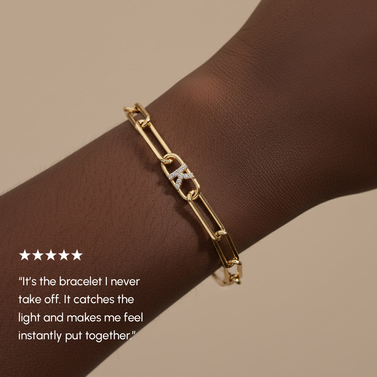 Gold bracelet on a wrist with a five-star rating and customer review text.