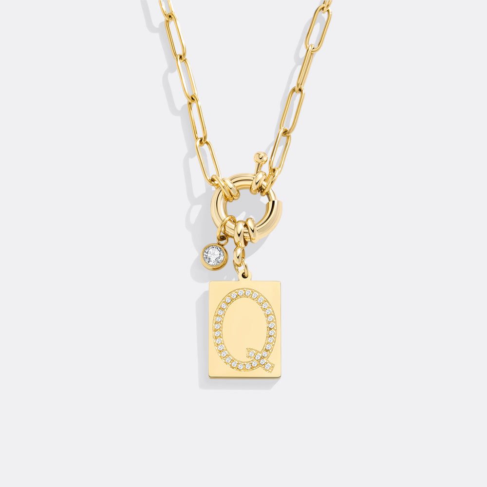 Gold necklace with a lock and key pendant on a light gray background