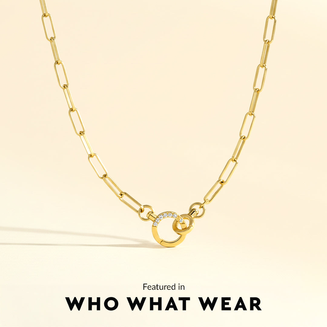 Gold necklace with a circular pendant on a beige background, featuring 'WHO WHAT WEAR'.