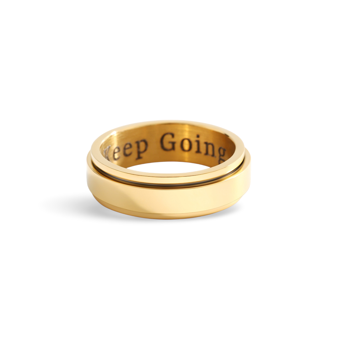 Gold ring with 'Keep Going' engraving on a white background
