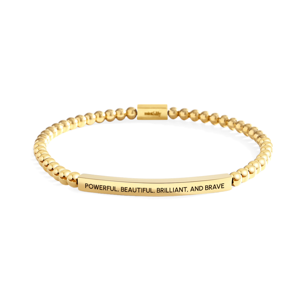 Gold bracelet with engraved message on a white background