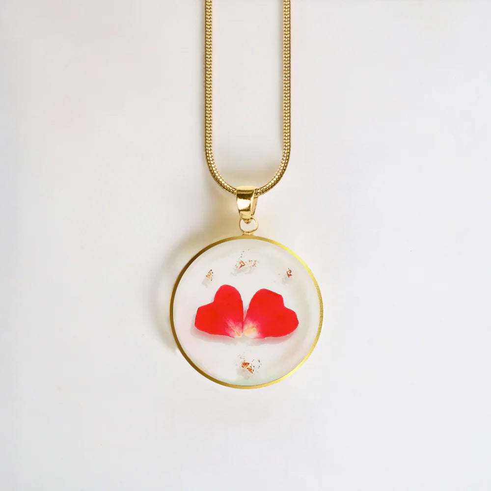 Necklace with a round pendant featuring red flowers on a white background
