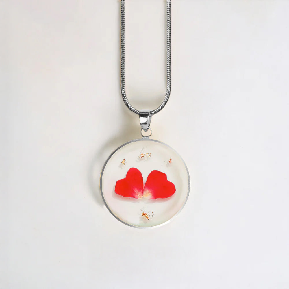 Necklace with a round pendant featuring red hearts on a white background