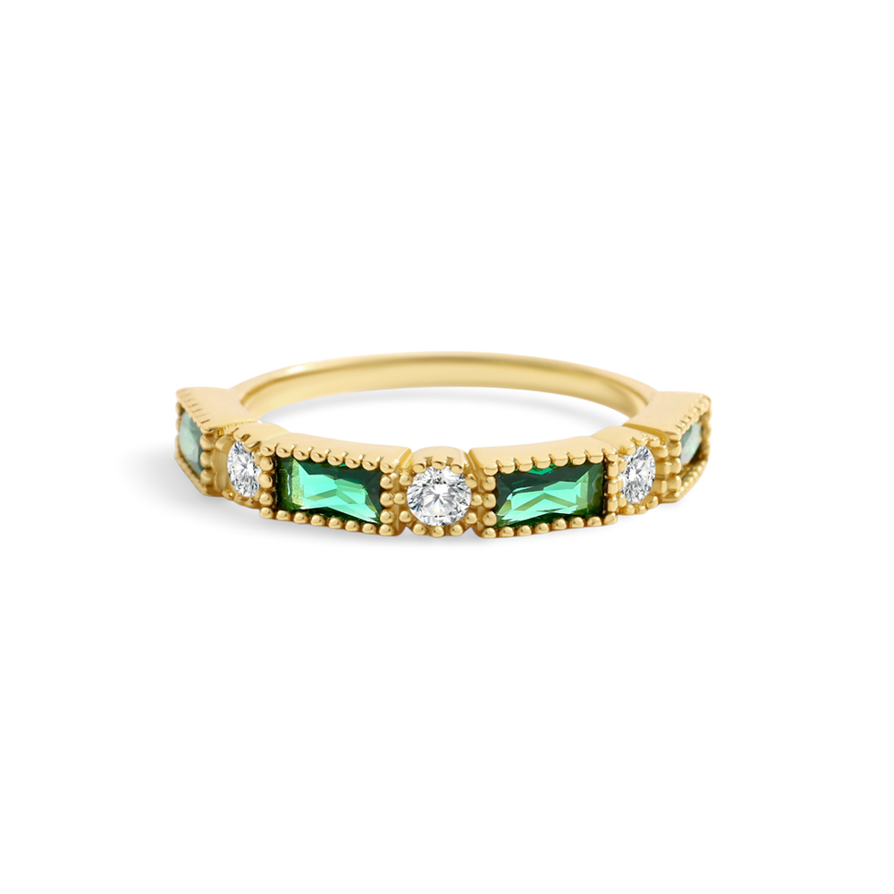 Gold ring with green gemstones and clear stones on a white background