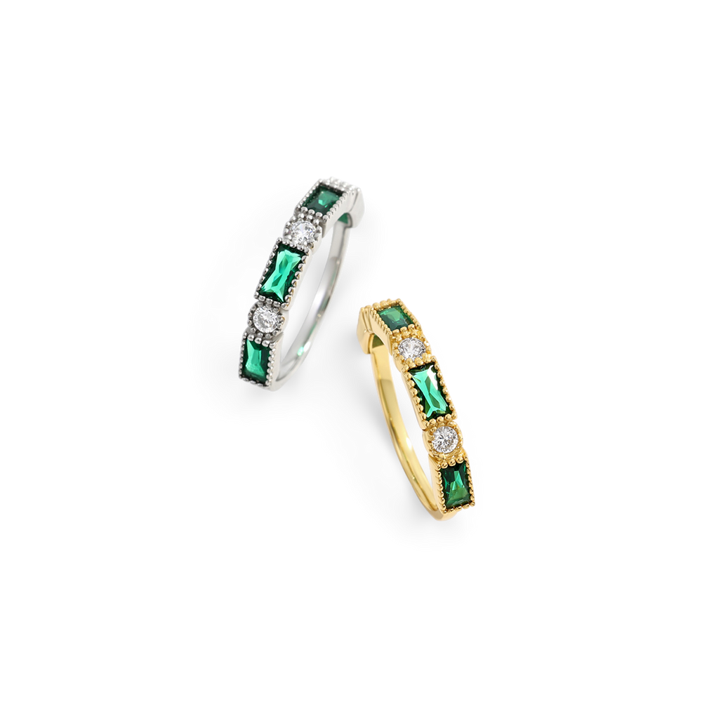 Two hoop earrings with green gemstones and clear stones on a white background