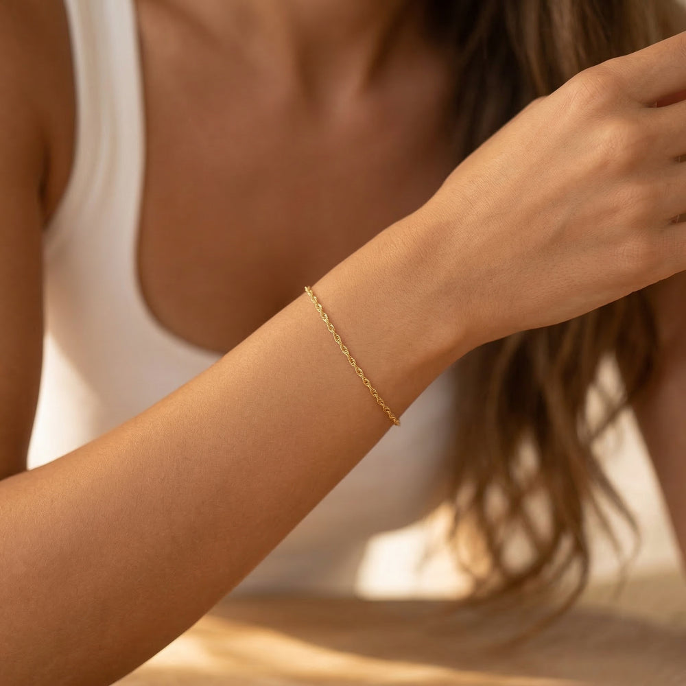 Close-up of a person wearing a gold bracelet on a blurred background