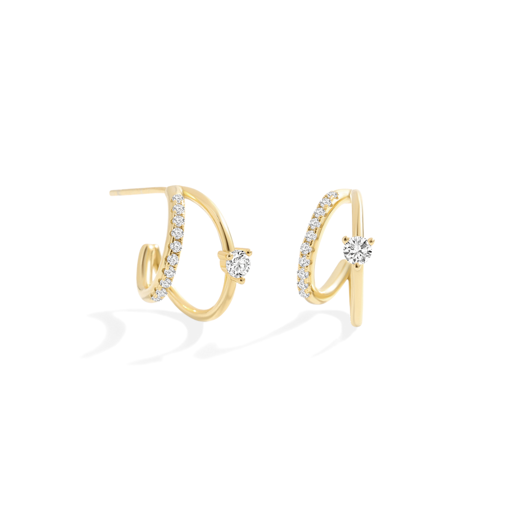 Gold hoop earrings with clear gemstones on a light gray background