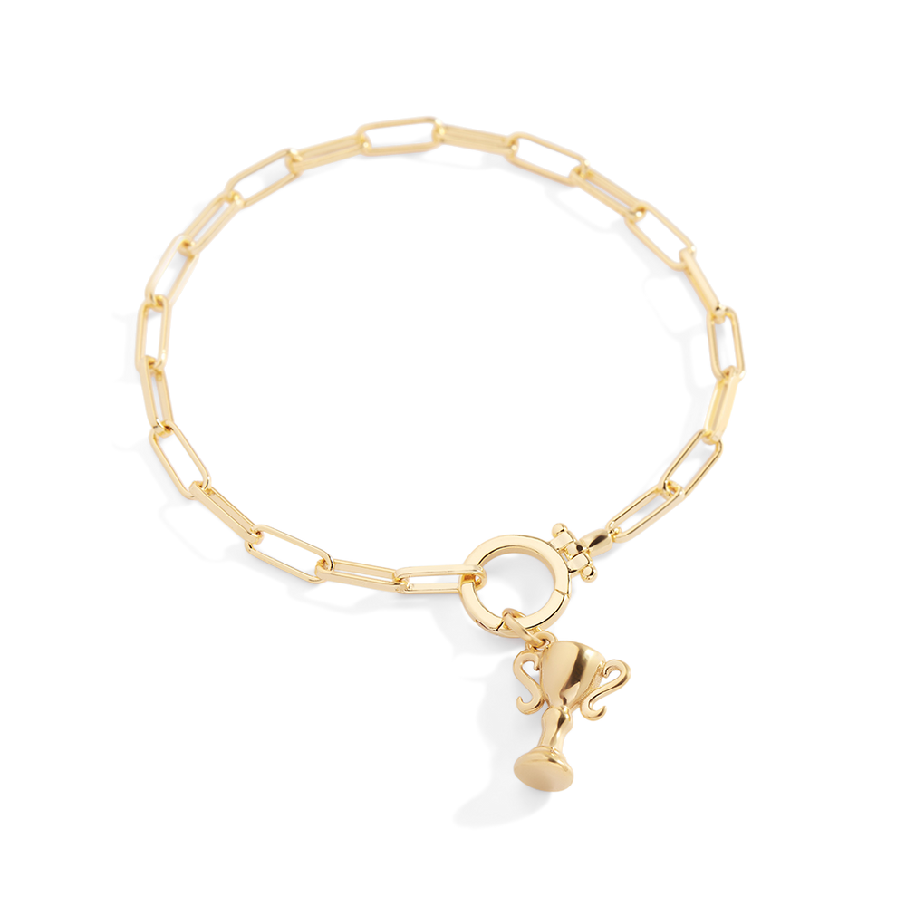 Gold bracelet with a small charm on a light gray background