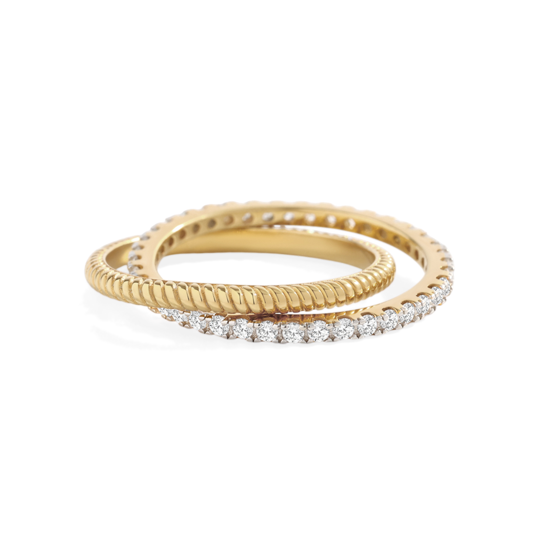 Two gold rings with diamond accents on a light gray background