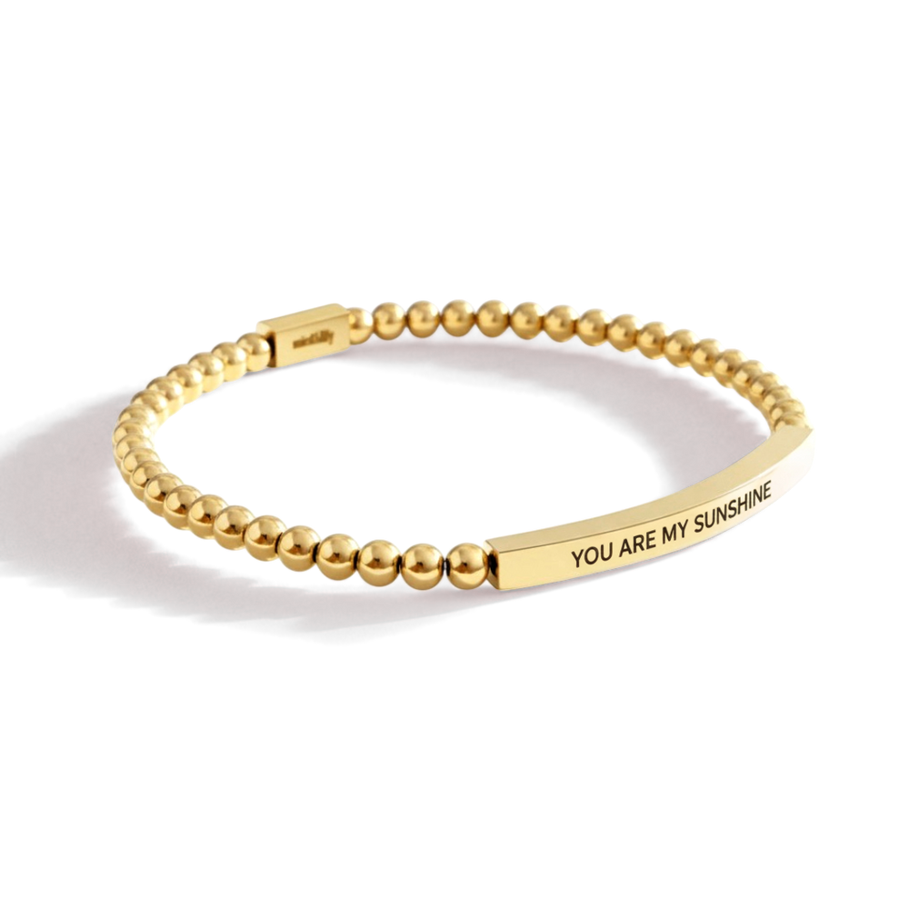 Gold beaded bracelet with 'You Are My Sunshine' engraving on a white background