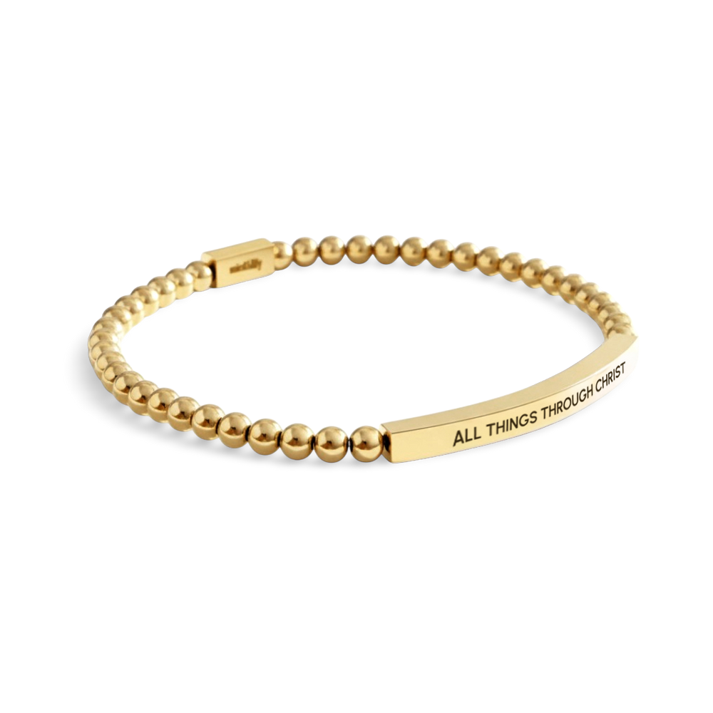 Gold beaded bracelet with engraved message on a white background