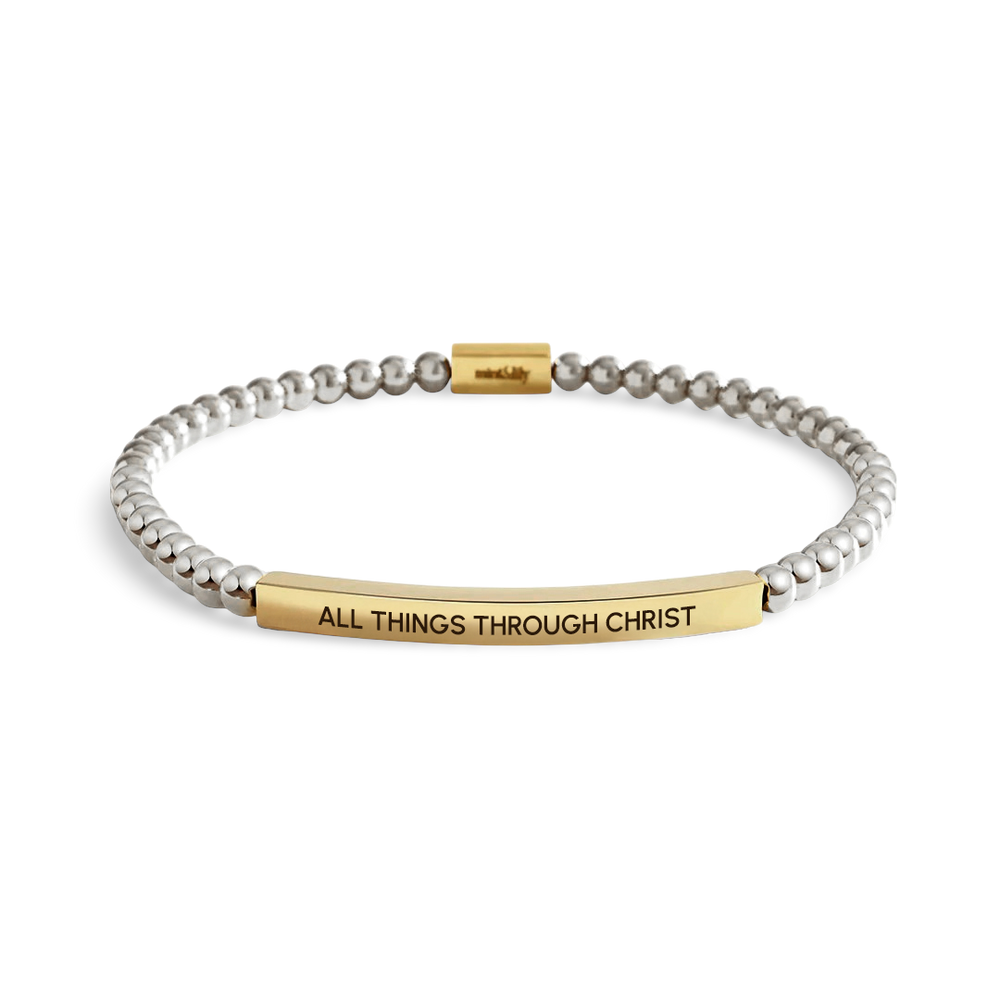 Bracelet with gold tag reading 'All Things Through Christ' on a white background