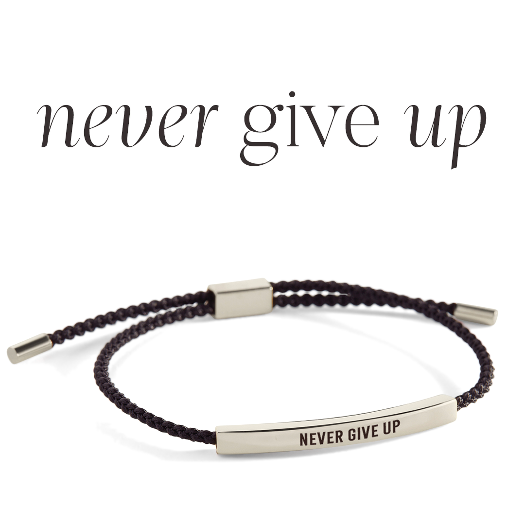 Bracelet with 'Never Give Up' engraving on a light background