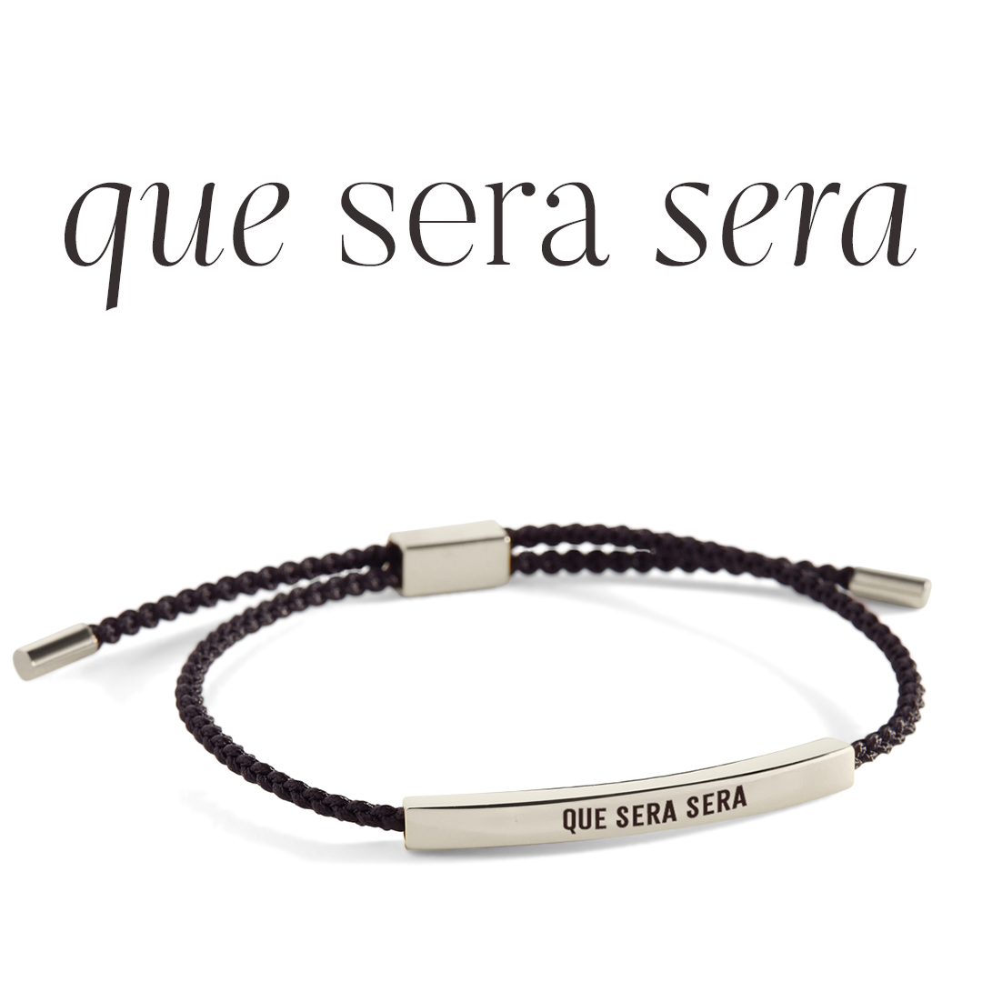 Bracelet with 'que sera sera' engraving on a light gray background