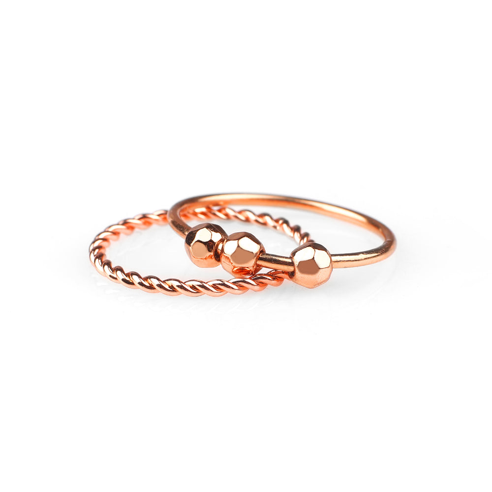 Rose gold ring with beaded design on a white background