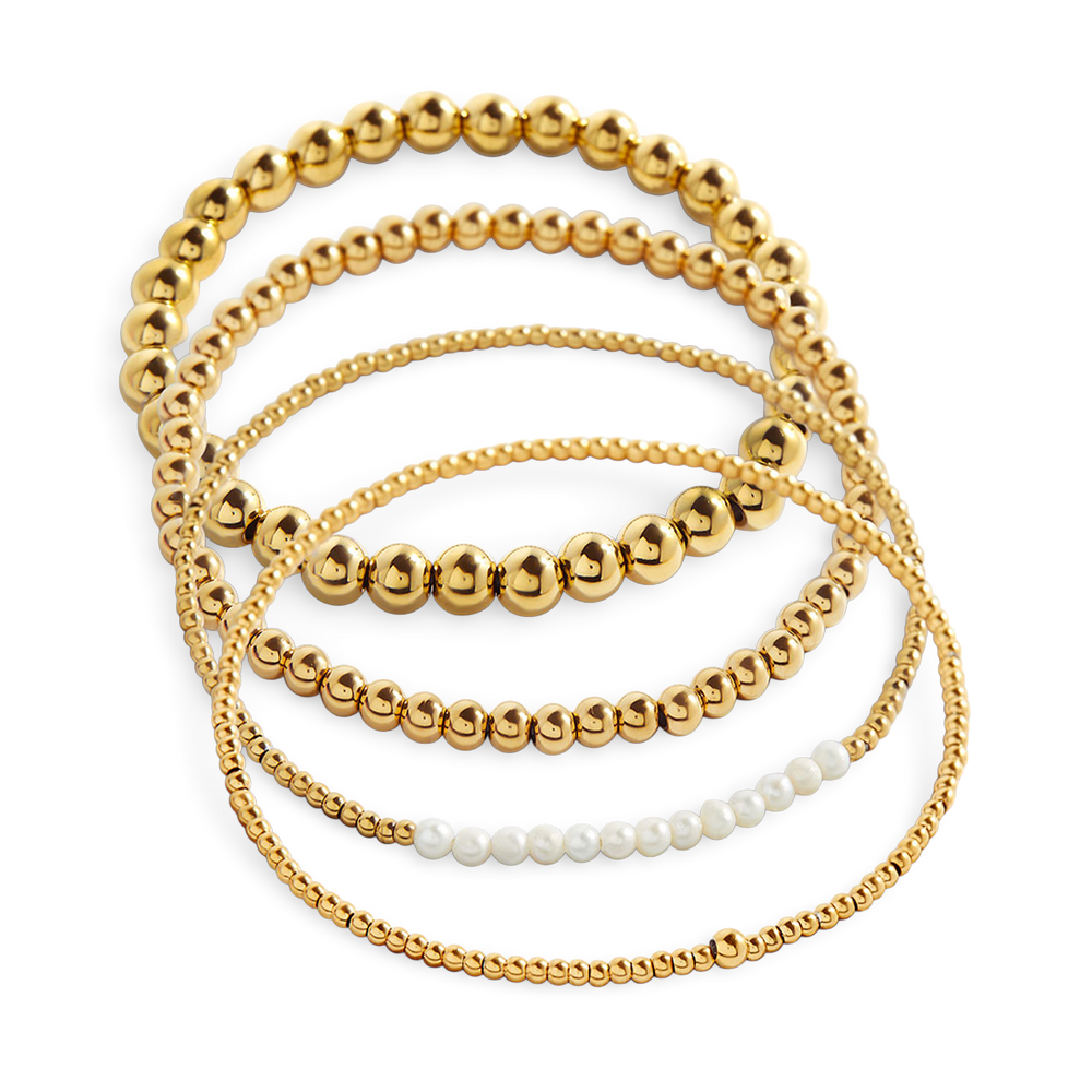 Set of gold beaded bracelets on a white background