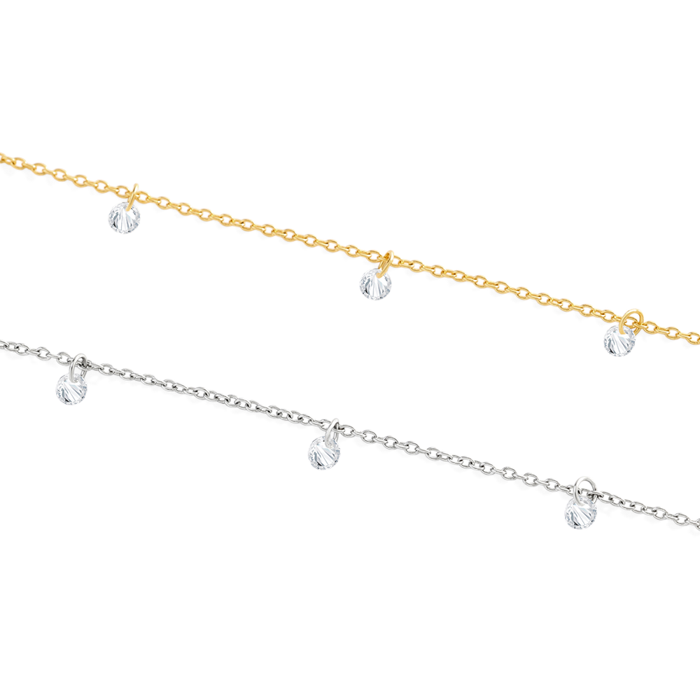 Two gold and silver anklets with clear crystals on a white background