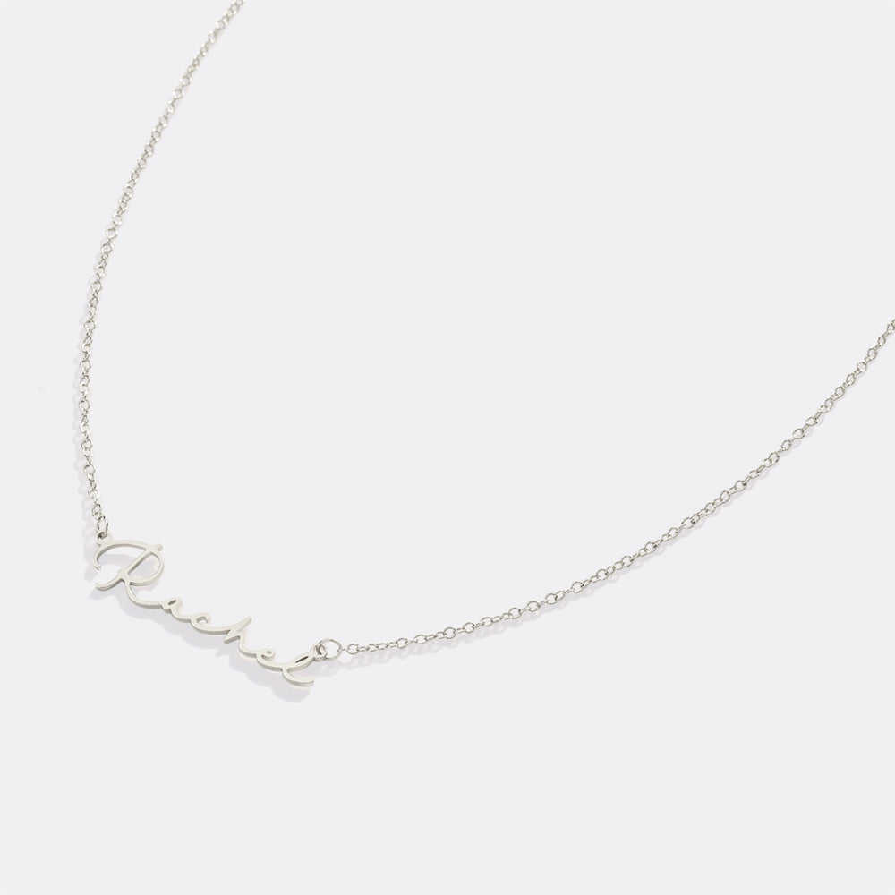 Silver necklace with 'love' pendant on a light gray background
