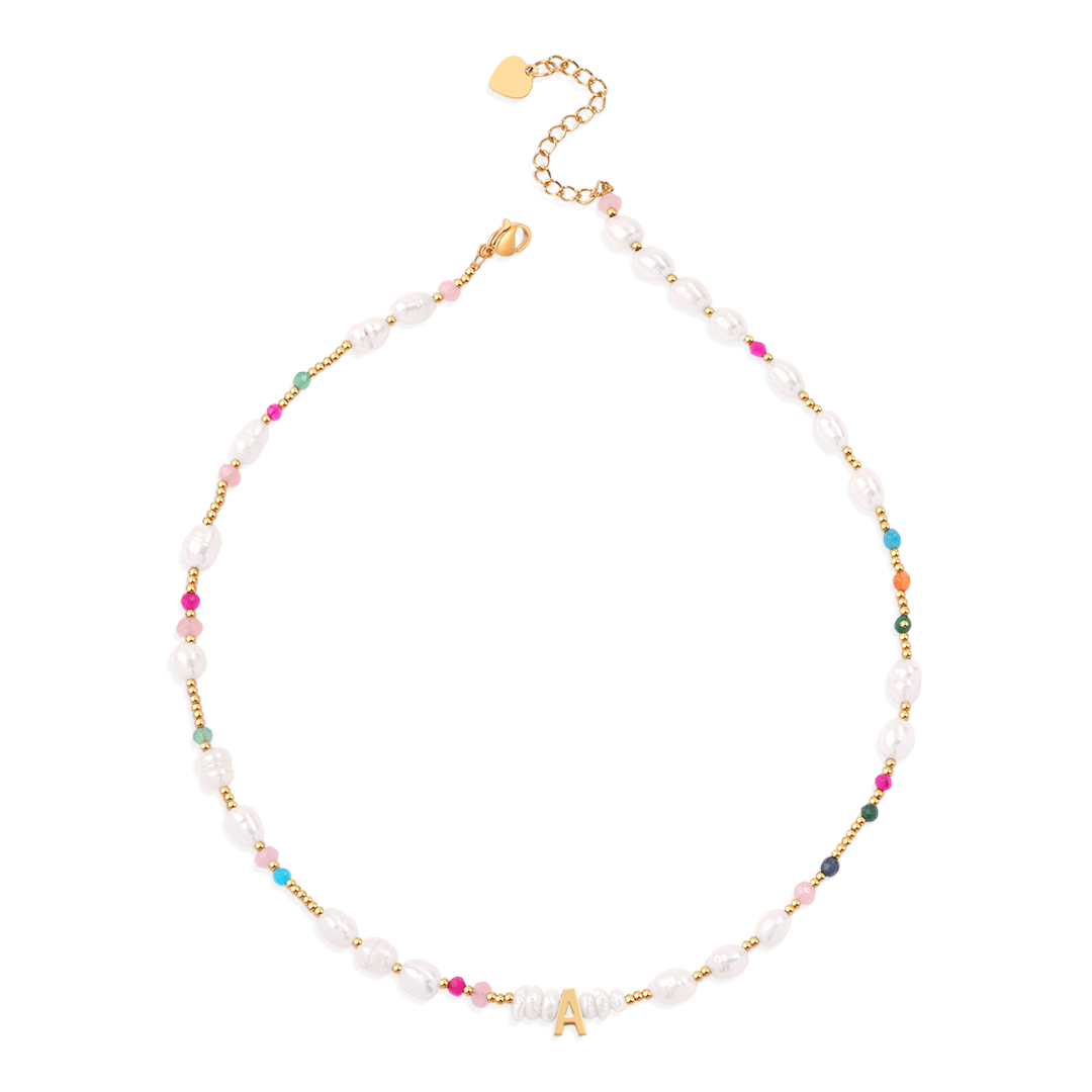A gold-colored initial necklace with white pearl and multicolored gemstone embellishments, displayed against a black background.