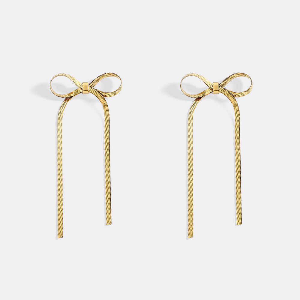 Gold bow-shaped earrings on a white background