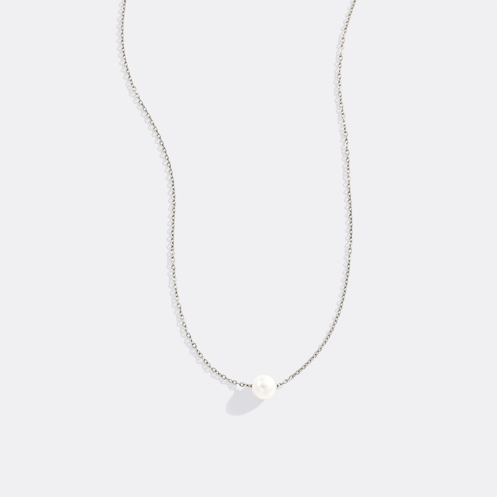Necklace with a single pearl pendant on a light gray background