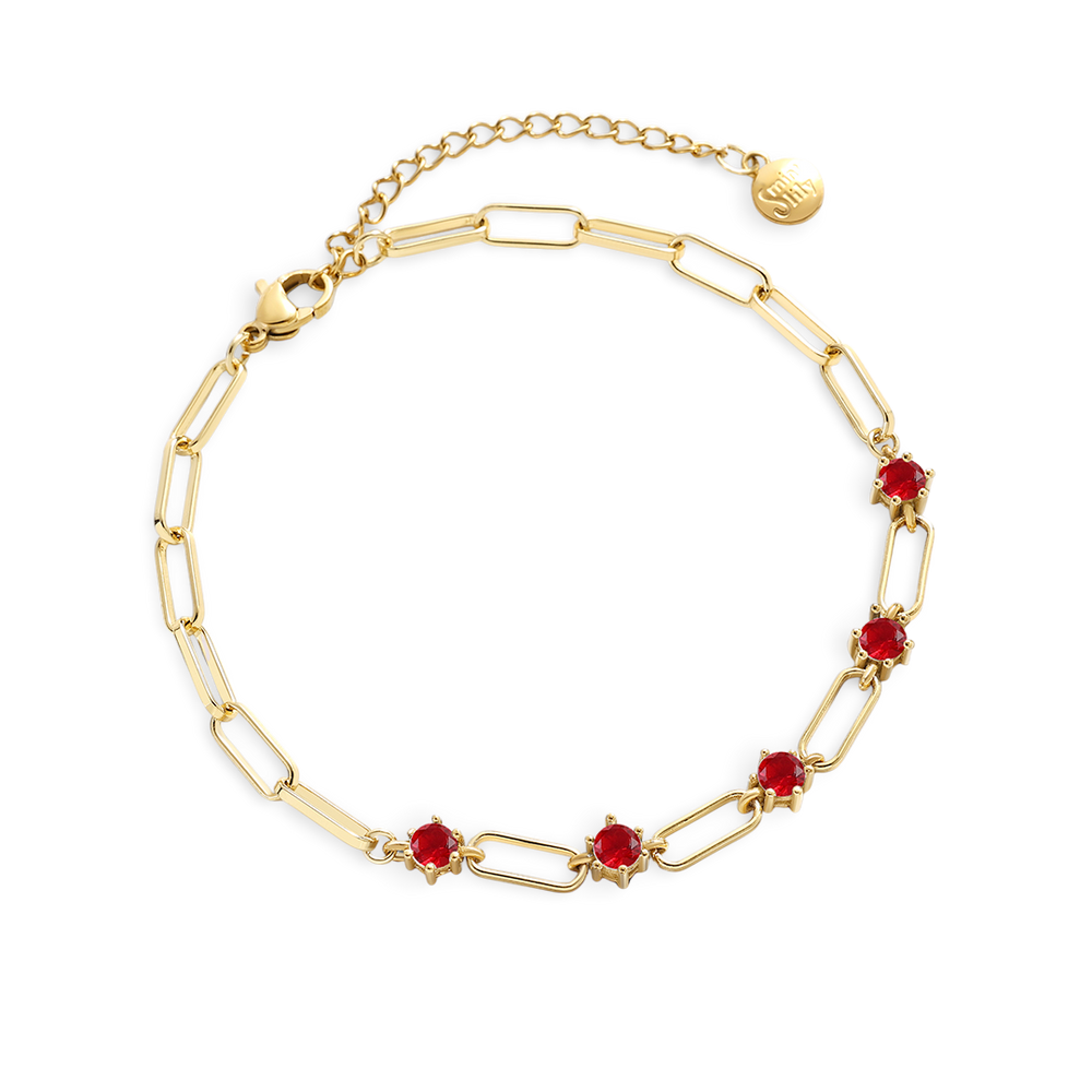 Gold bracelet with red gemstones on a white background