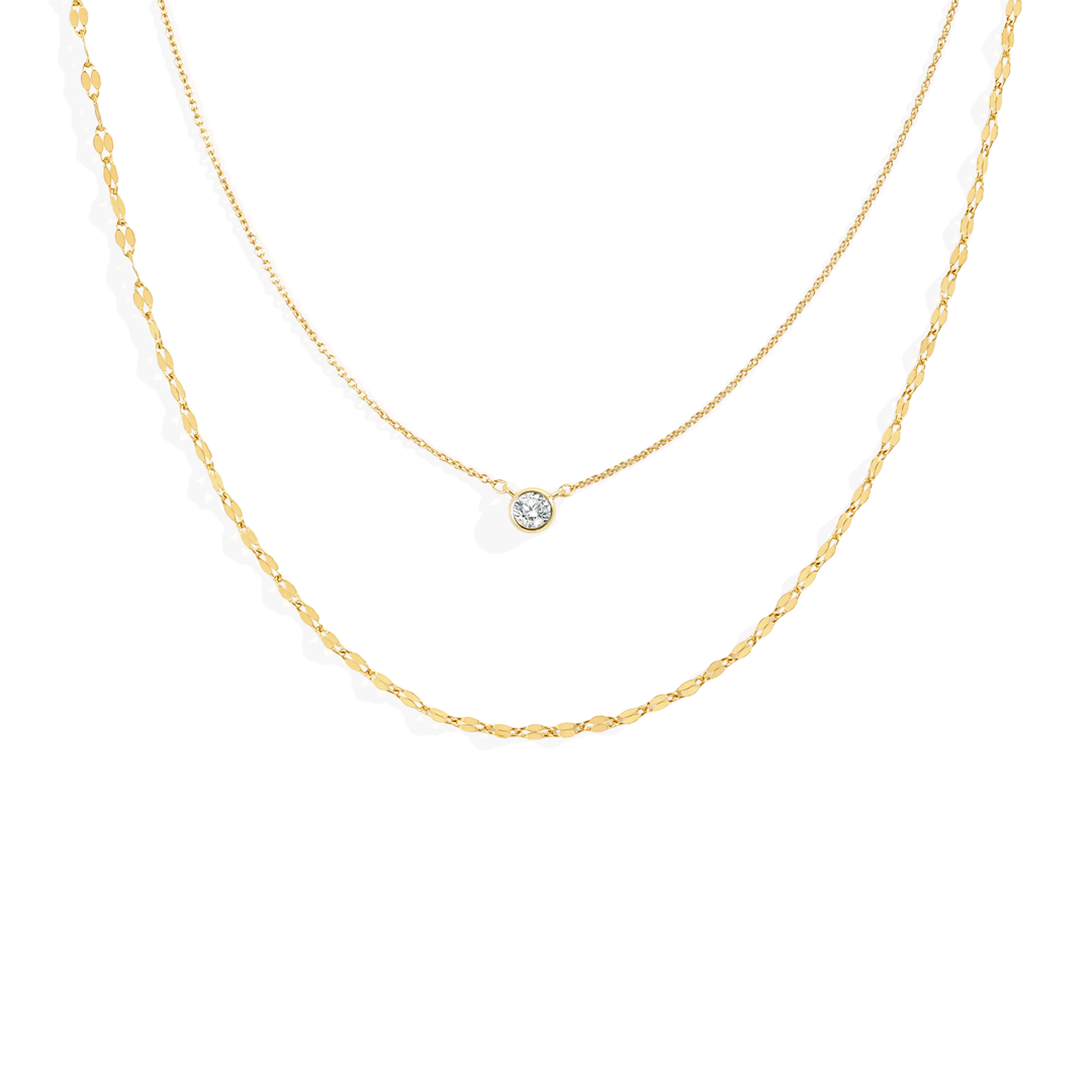 Gold necklace with a small round pendant on a white background