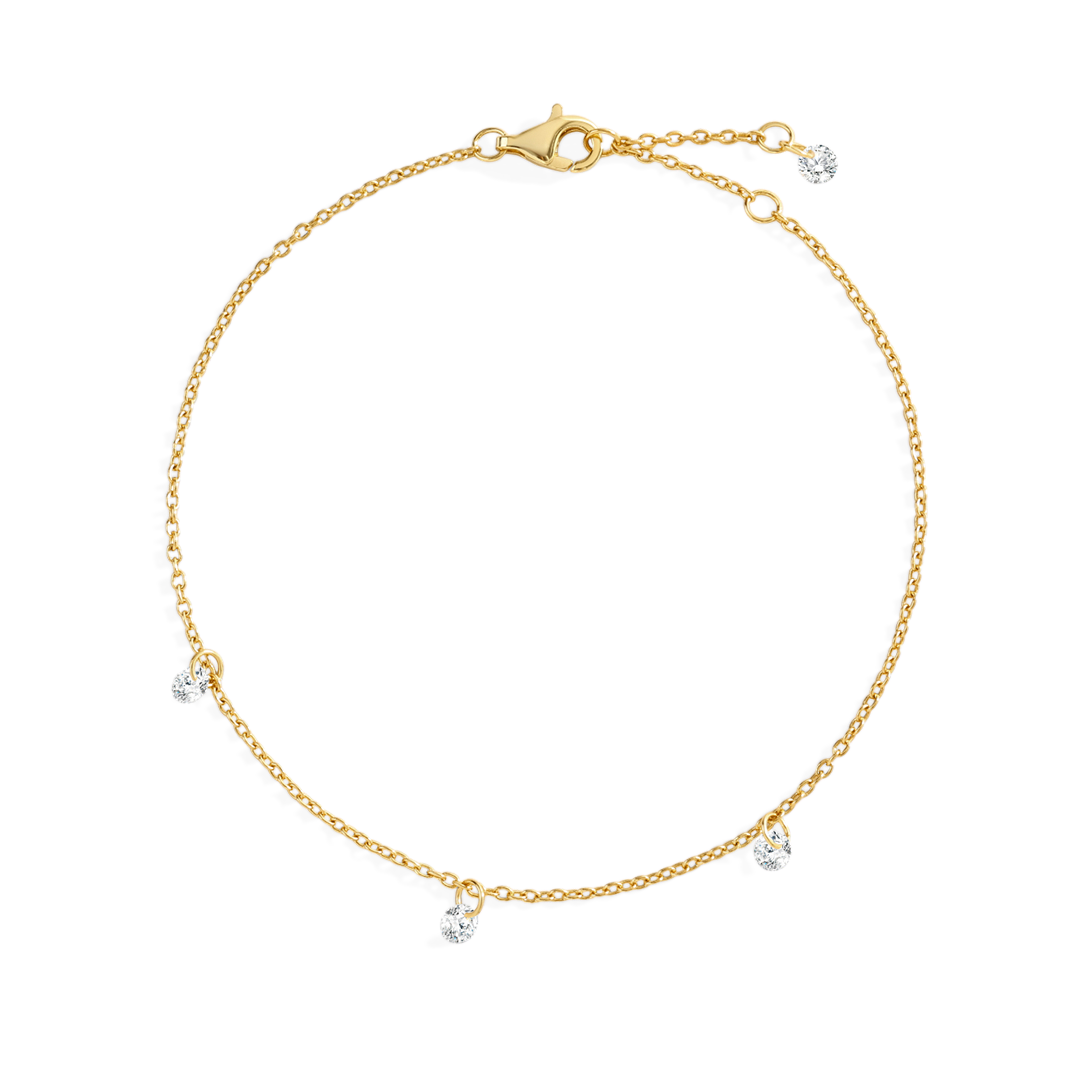 Gold bracelet with small dangling charms on a light gray background