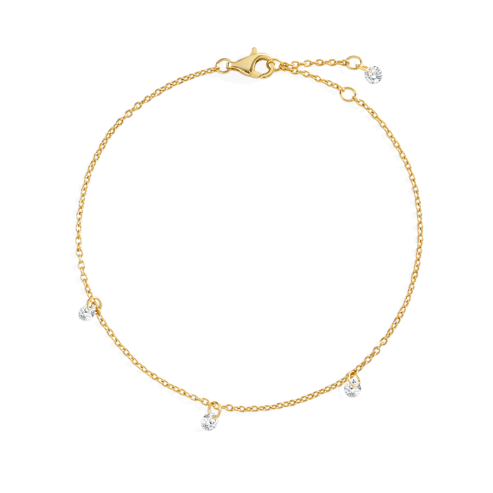 Gold bracelet with small dangling charms on a light gray background