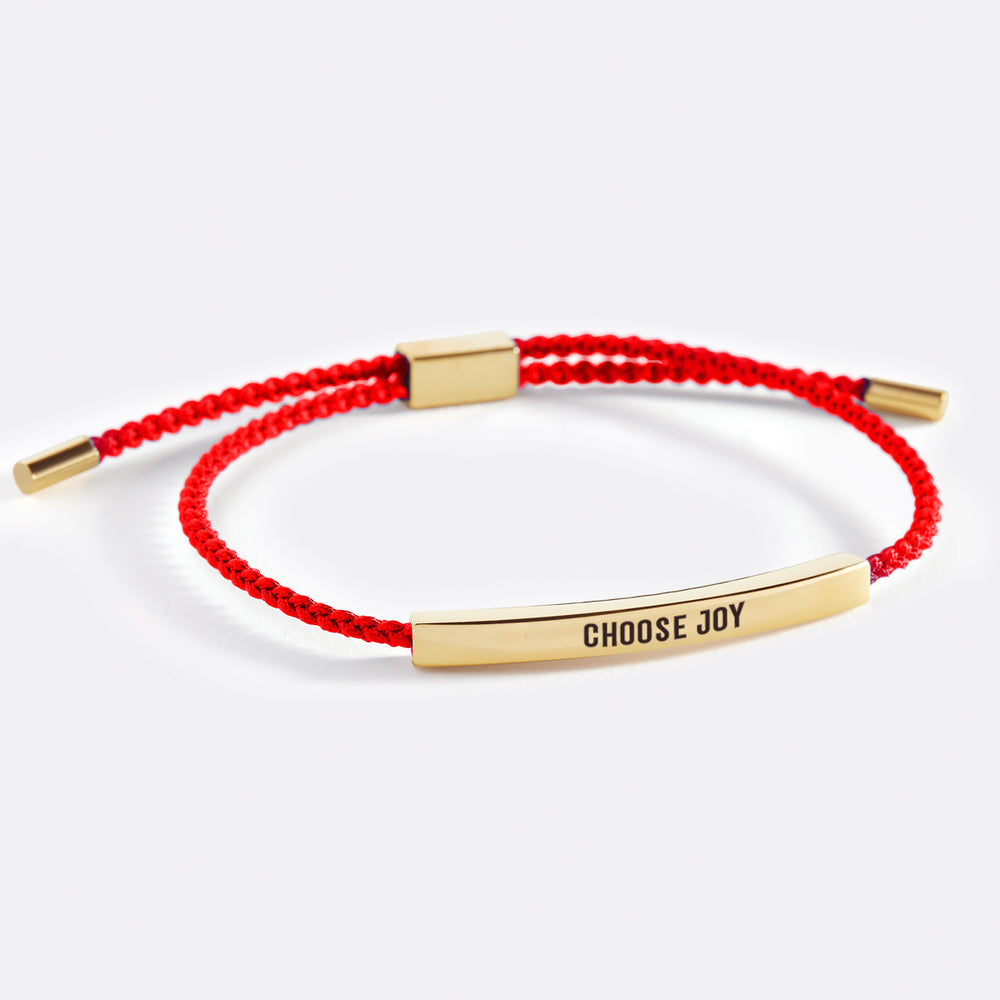 A bracelet with the text 'choose joy' printed on it, displayed on a white background.