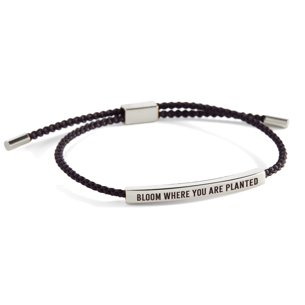 An inspirational bracelet with the phrase 'bloom where you are planted' printed on it, featuring a braided design in a dark color with metal accents.