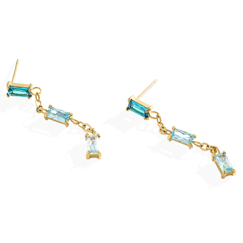 Gold earrings with blue gemstones on a white background