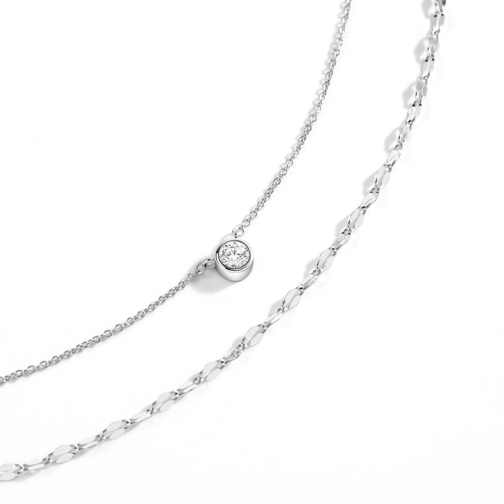Silver chain necklace with a small round pendant on a white background