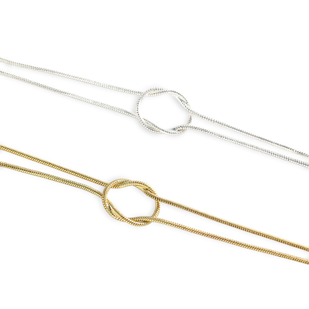 Two gold and silver necklaces on a white background