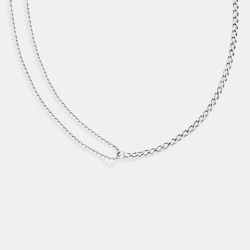 Silver chain necklace on a light gray background