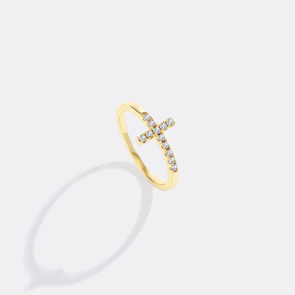 Gold ring with small diamonds on a light gray background