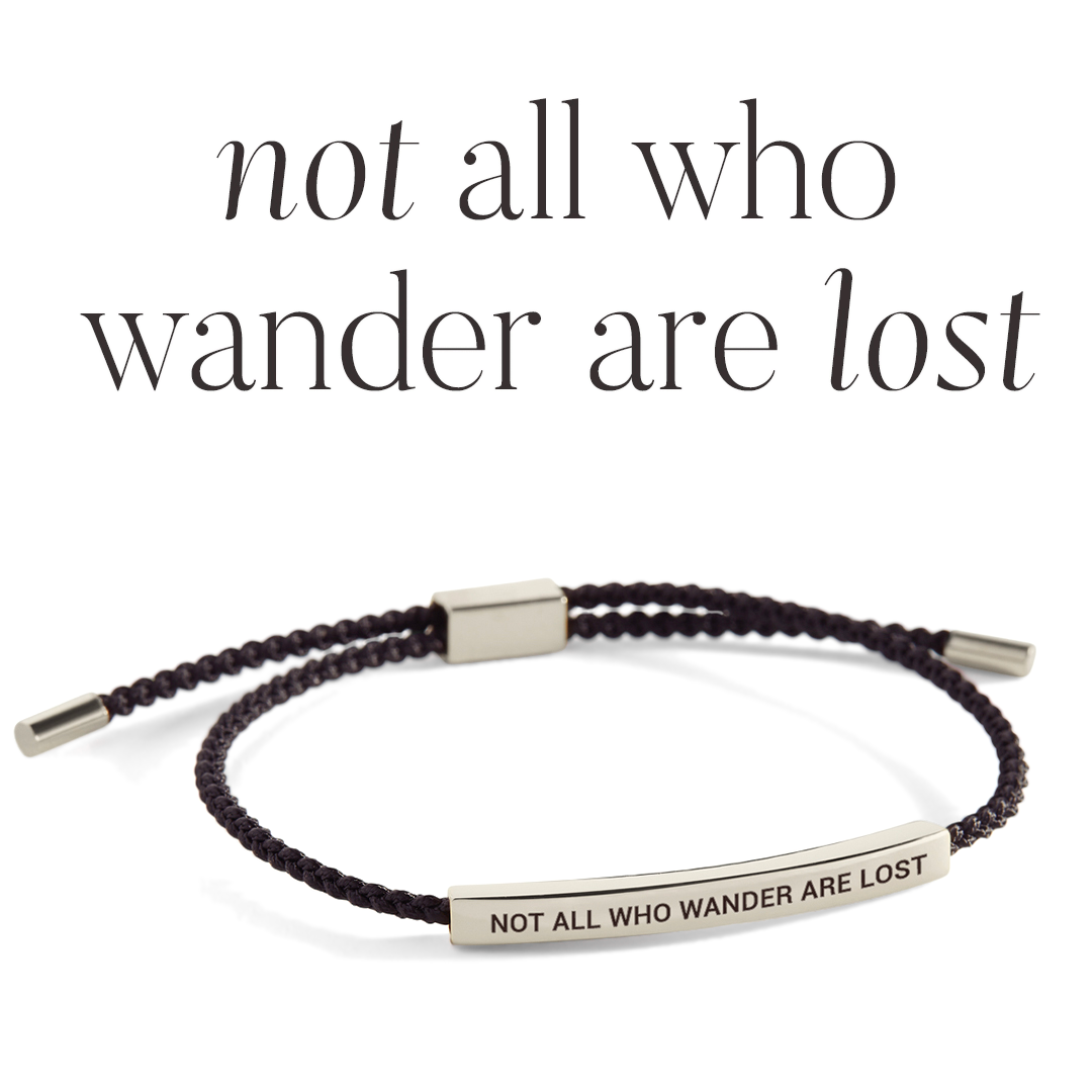 Bracelet with 'Not All Who Wander Are Lost' message on a light gray background