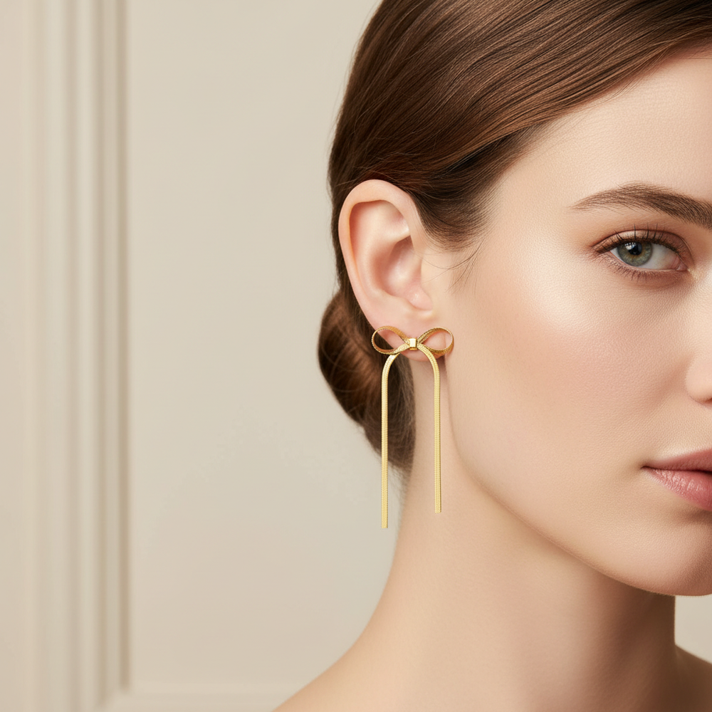 Gold earring on a model's ear against a neutral background