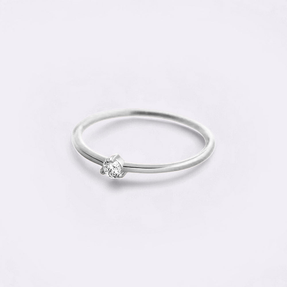 Silver ring with a diamond on a light gray background