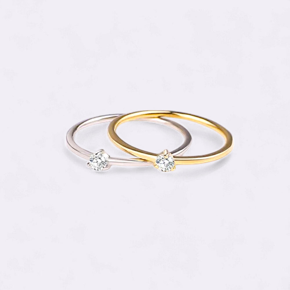 Two gold rings with embedded diamonds on a light gray background